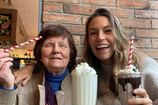 Two women enjoying a milkshake together.